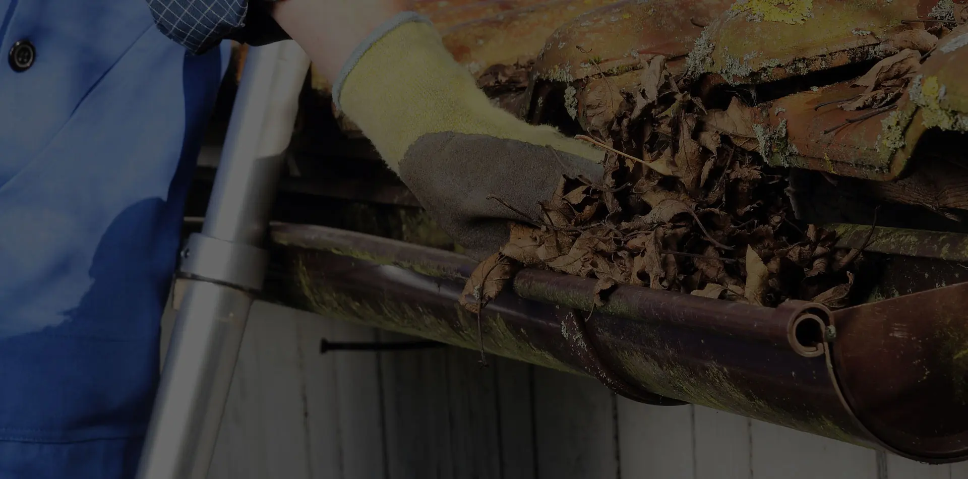 Clearing leaves from a townhouse gutter